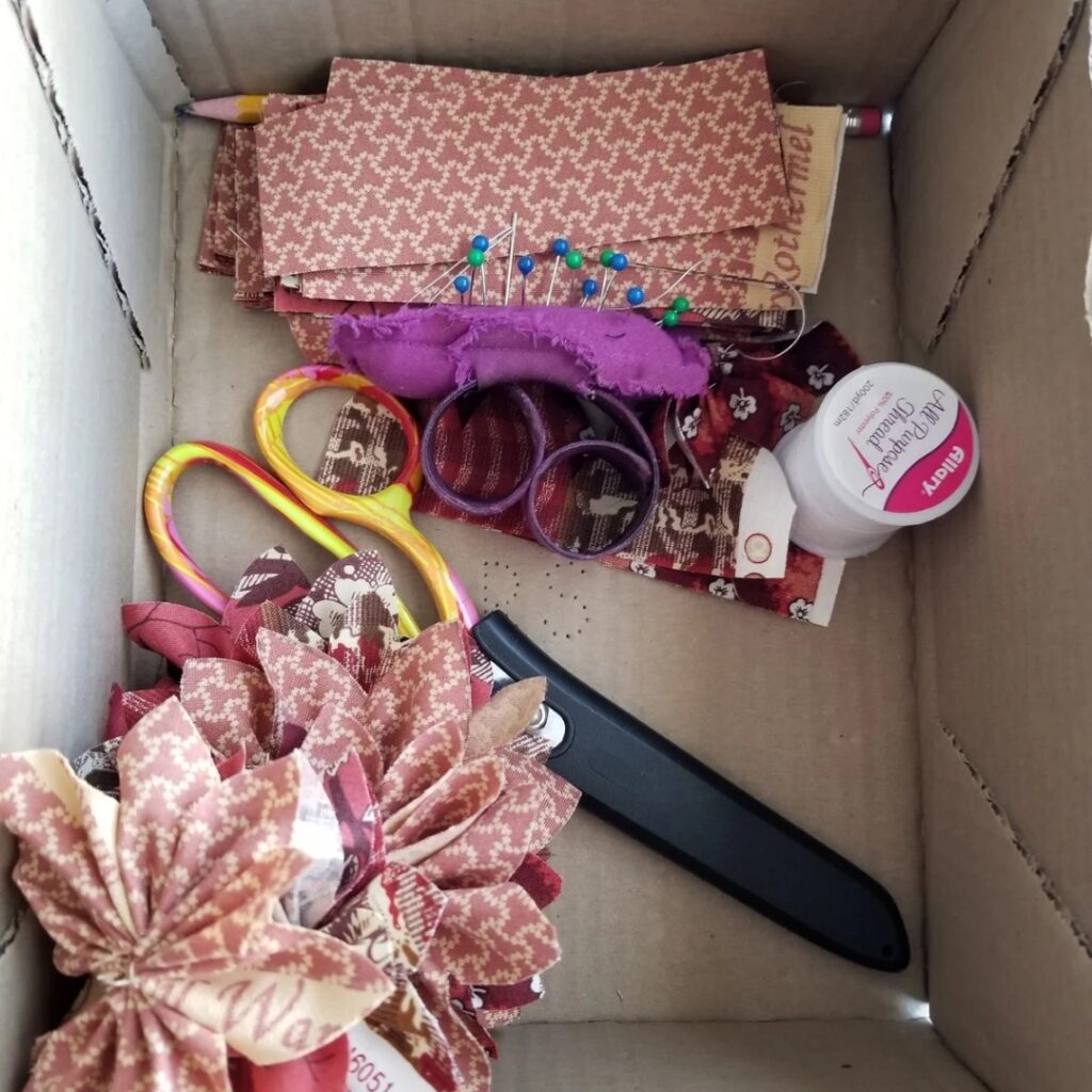 Collection of flower sewing supplies in a cardboard box.